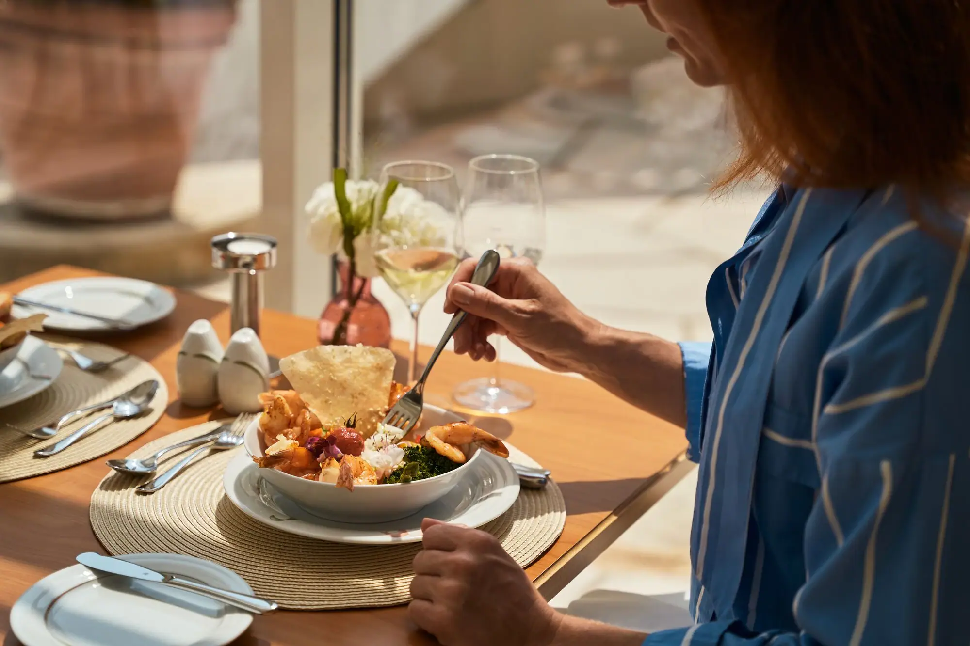 Lunch A woman is eating a bowl of food.