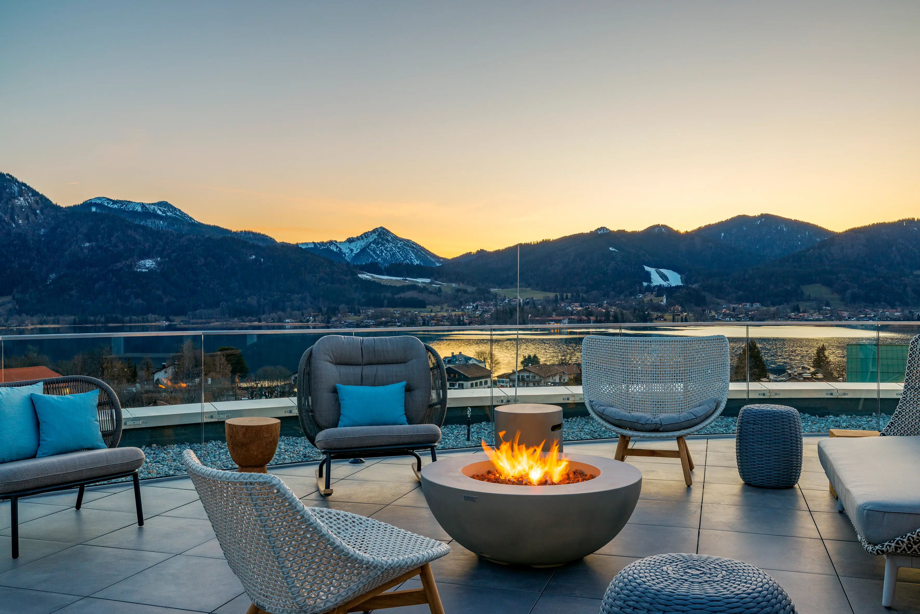Rooftop bar A fire pit with chairs and a view of the mountains in the background