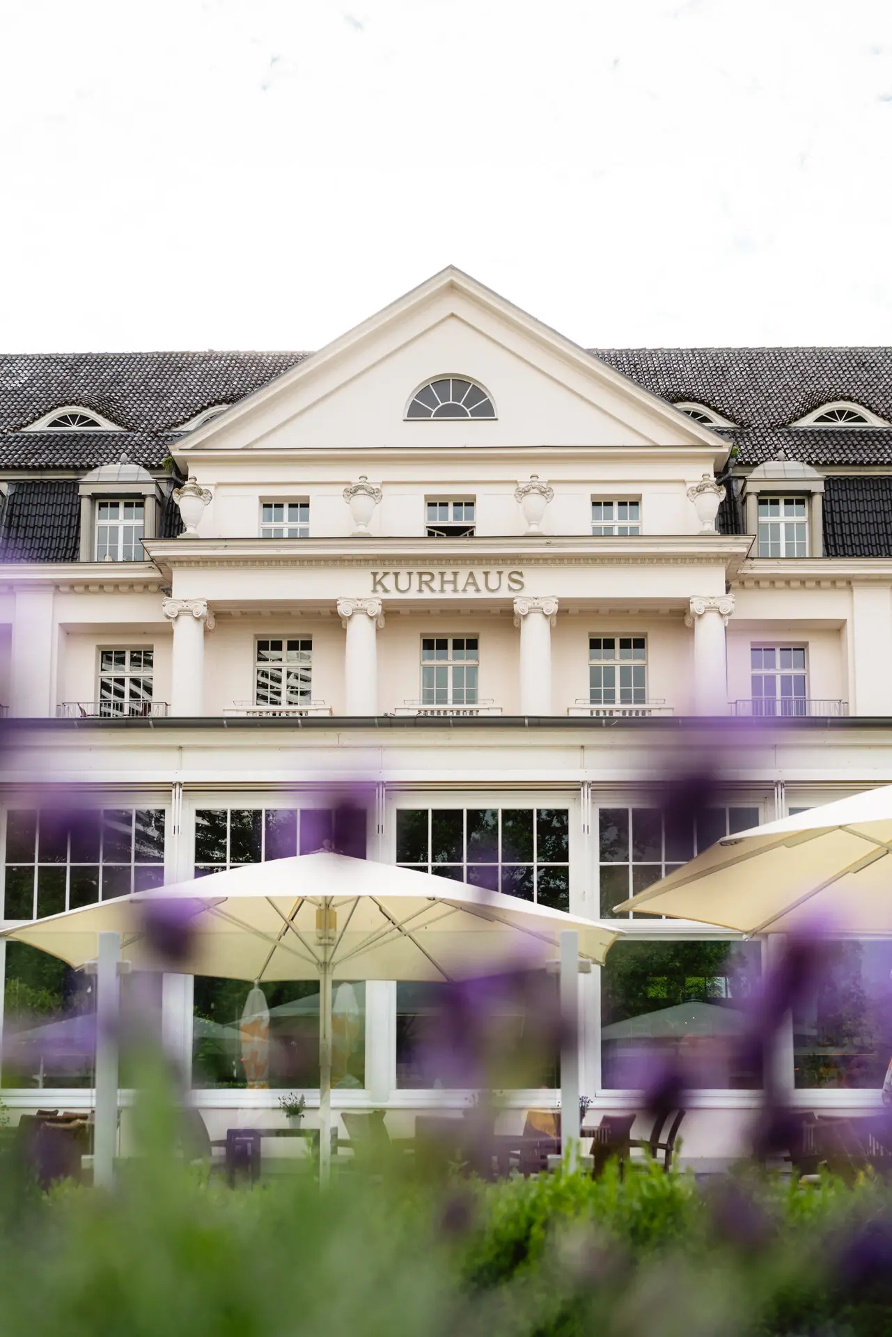 A-ROSA Travemünde A building with a large window and a large parasol.