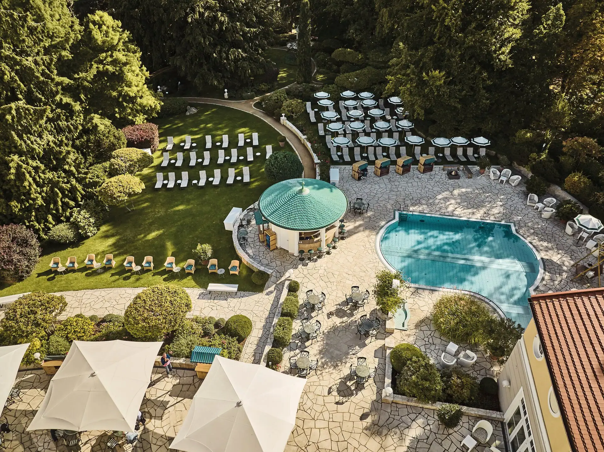 Außenterrasse Ein Pool mit Liegestühlen in einem Garten.