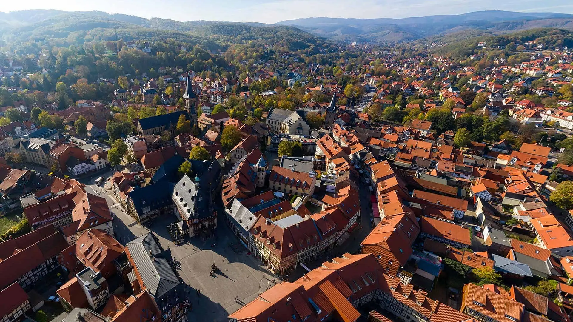 Wernigerode Aerial view of a town with houses, trees and mountains in the background.