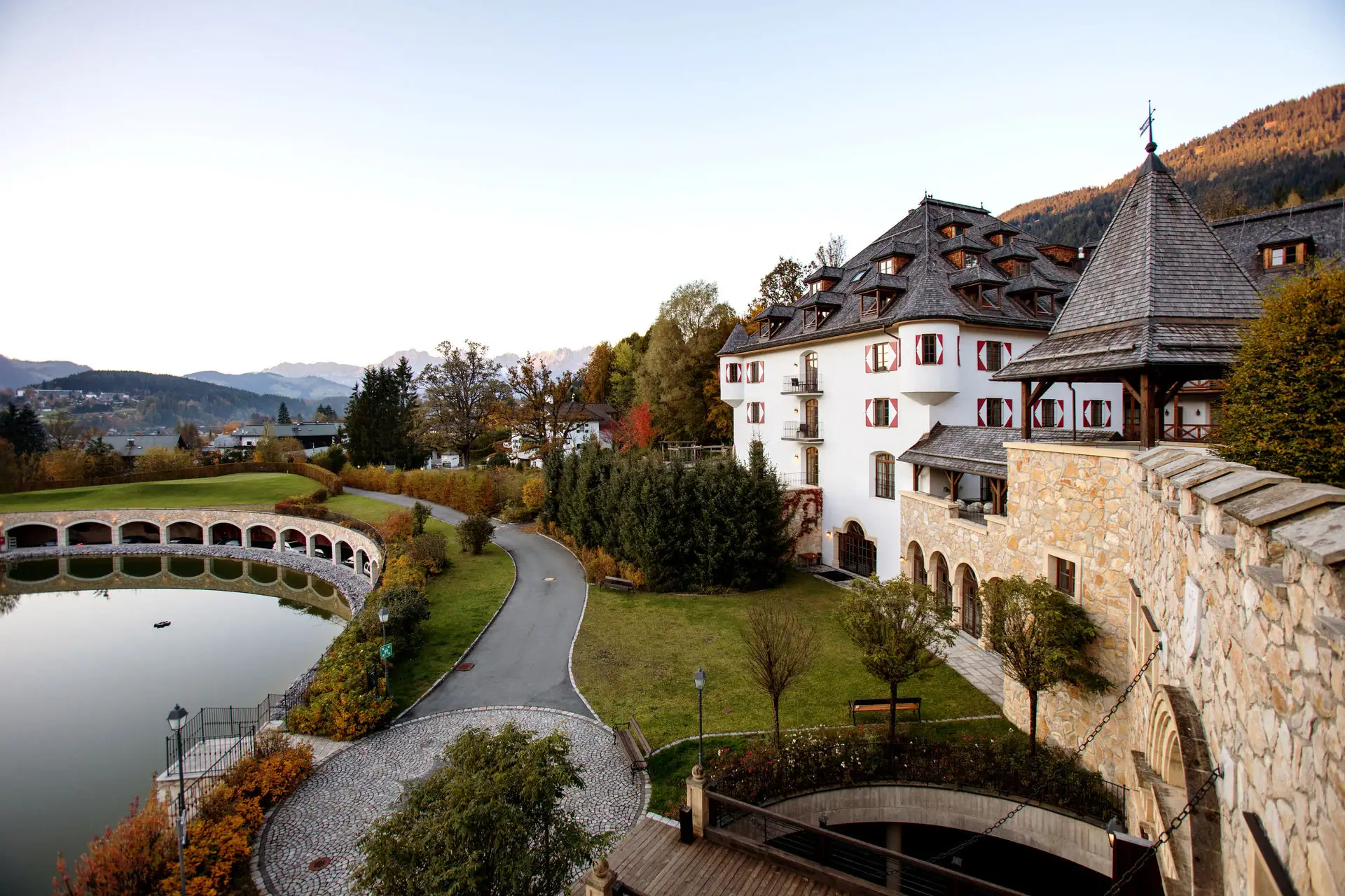 Kitzbühel Castle Hotel A building with a bridge and a body of water.