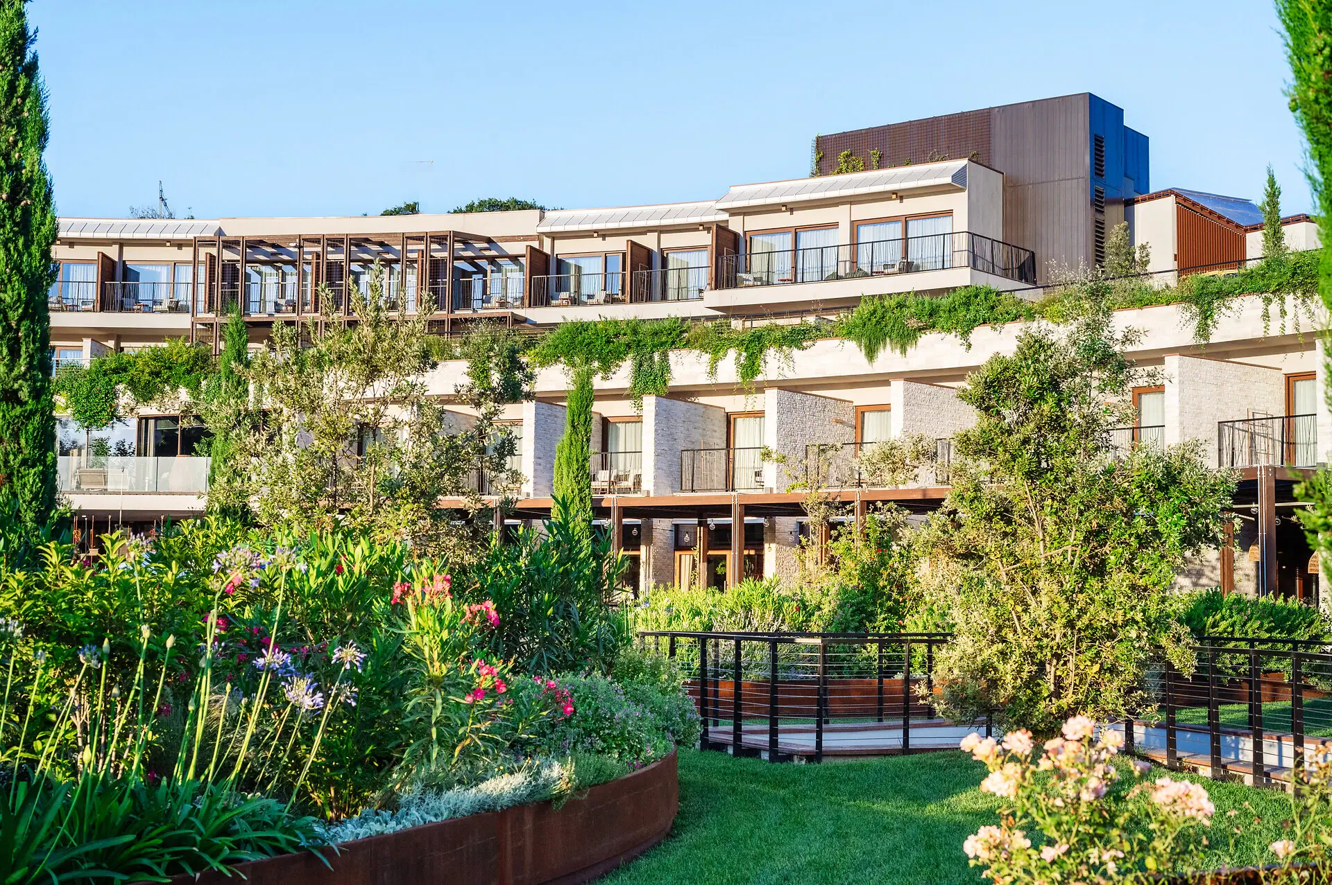 A-ROSA Hotel on Lake Garda Garden A building with a garden and plants.