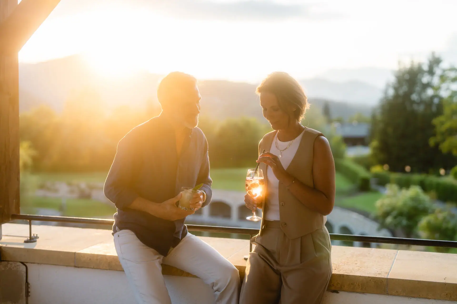 Terrasse Ein Mann und eine Frau halten Getränke.
