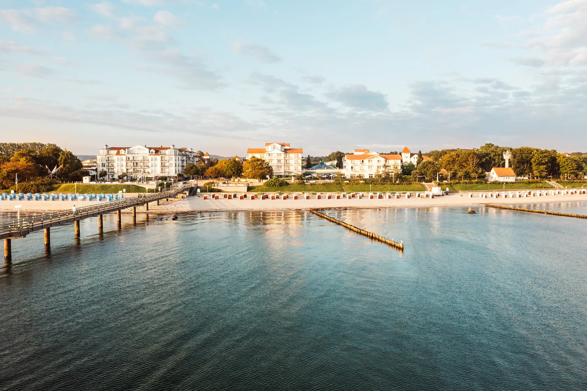 A-ROSA Ostseehotel Kühlungsborn Ein Gewässer mit einem Steg und Gebäuden im Hintergrund.