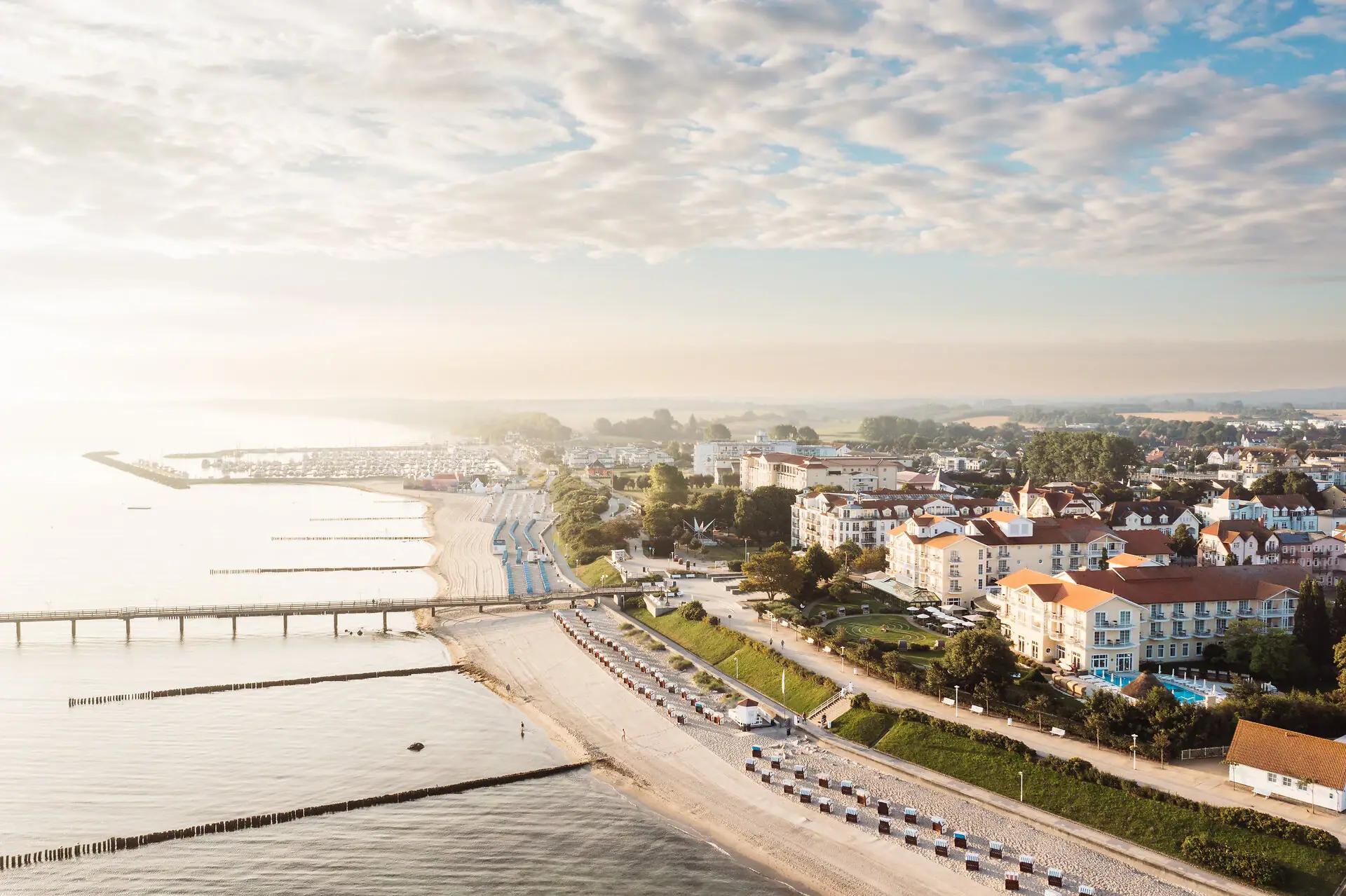 Kühlungsborn Beach with buildings and a bridge in the background.